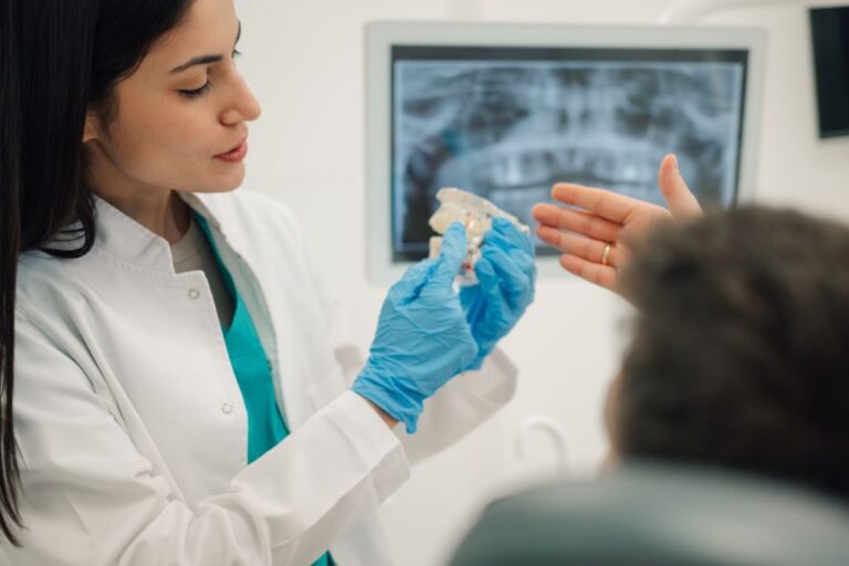 dentist showing teeth model to patient in dental