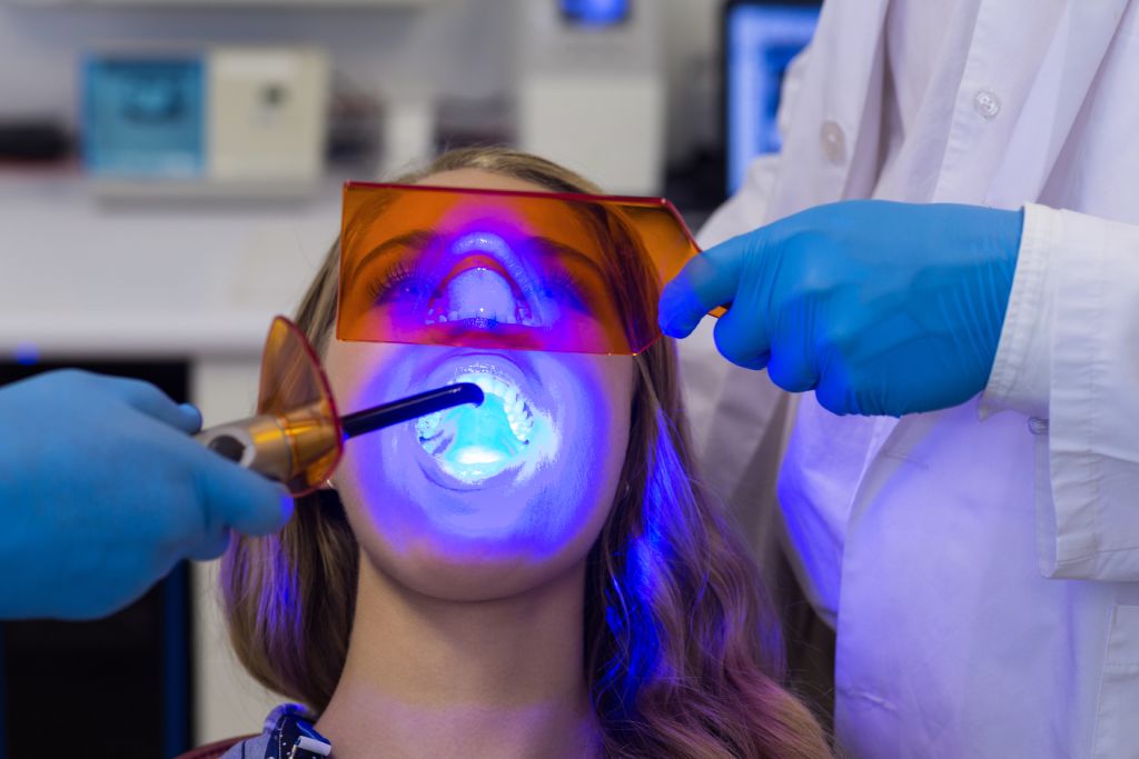 dentists examining female patient with dental care
